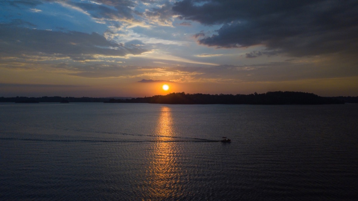 Pôr do sol na represa Guarapiranga, com um barco